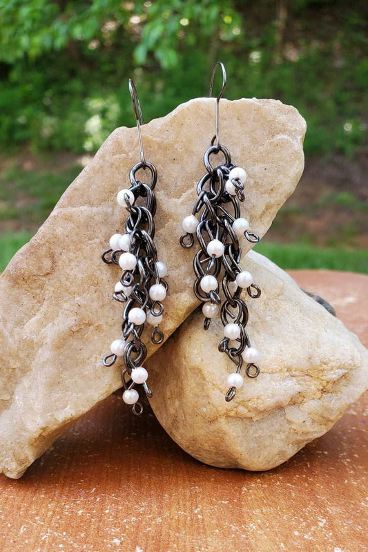 Pearl earrings, photo of pearl earrings on a rock, Gunmetal Pearl Dangle Earrings, handmade earrings, Jiana Deon brand